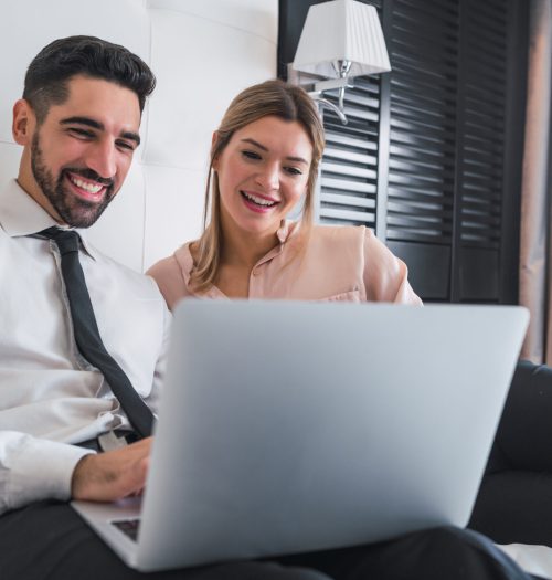 Twee mensen uit het bedrijfsleven werken samen op laptop.